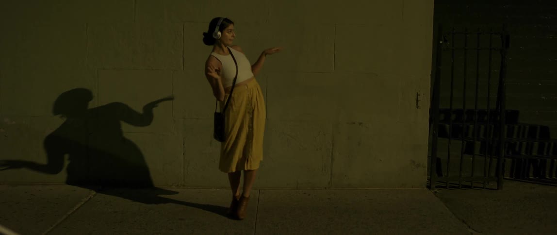 A woman dances on the city sidewalk