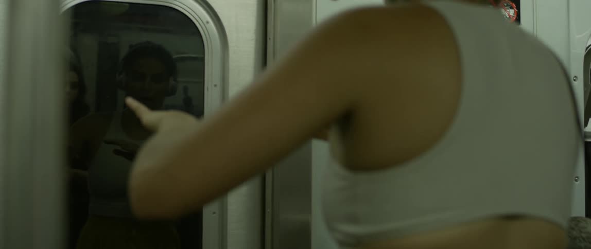 A woman dances while riding a subway train