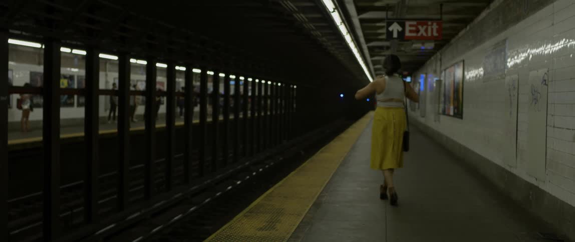 A woman dances playfully in a subway station
