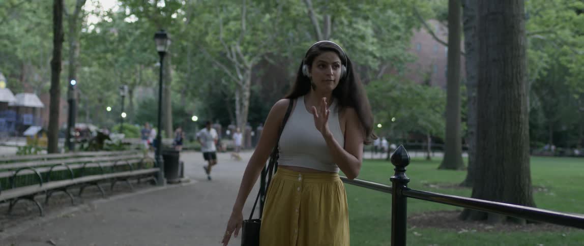 Woman listening to music and dancing in the park