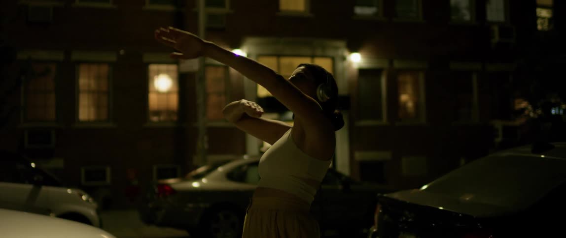 A woman playfully dances in the street