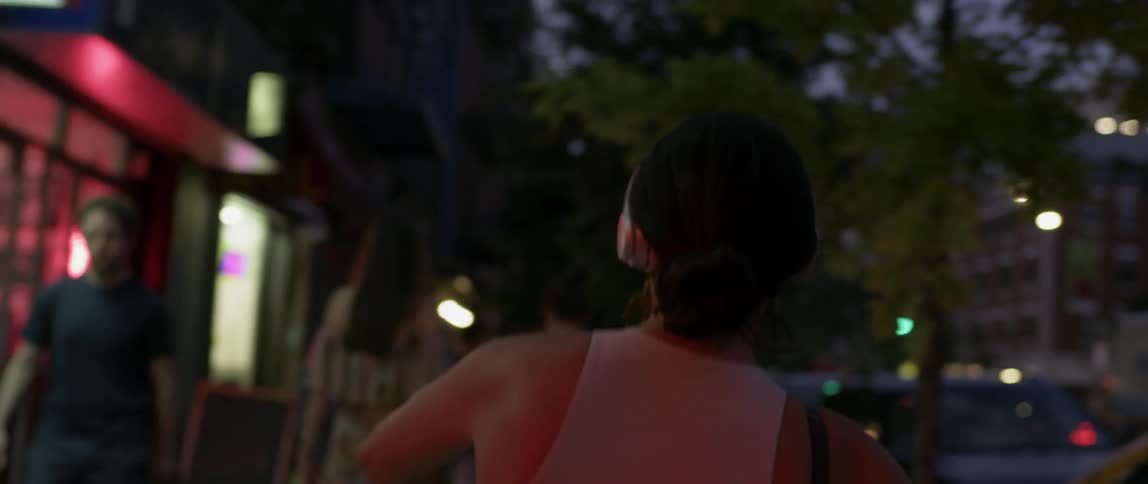A woman dances on the sidewalk at night