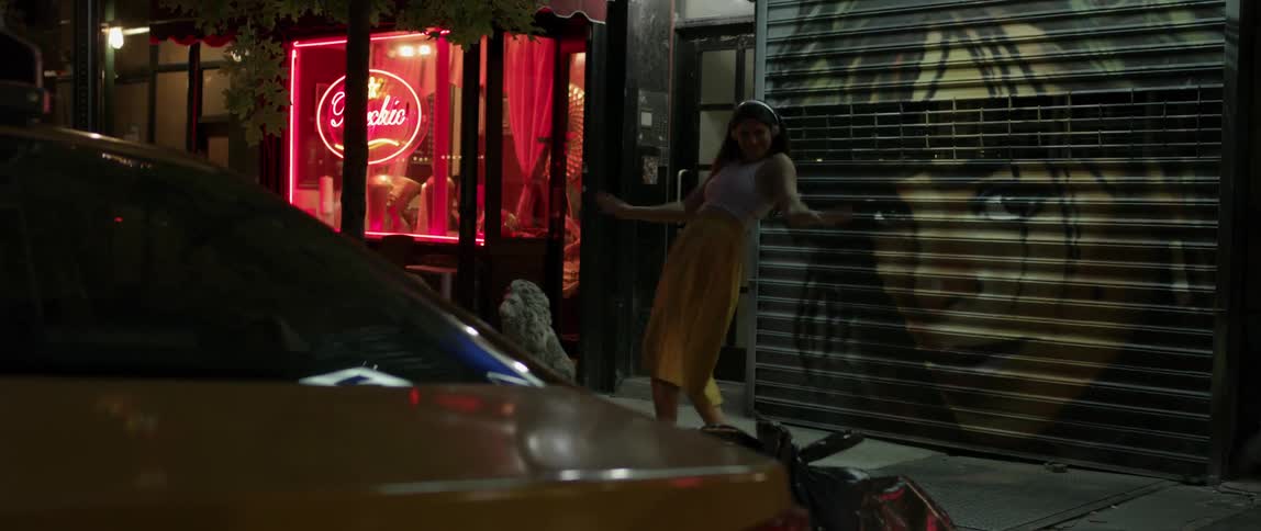 Woman listening to music and dancing in the street at night