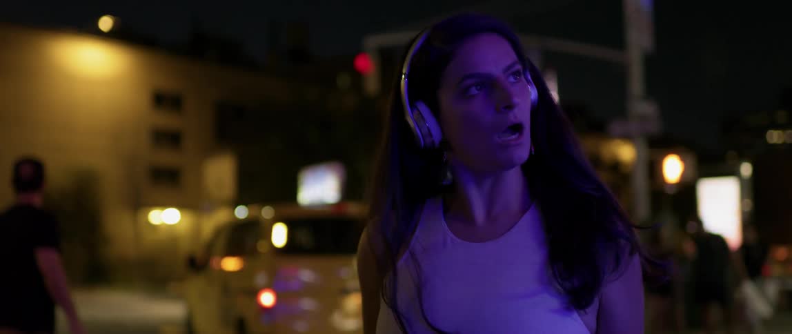 A woman dances playfully at night