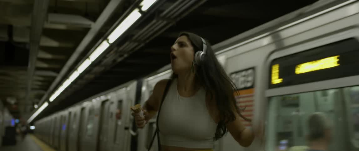 A woman dances playfully in a subway station