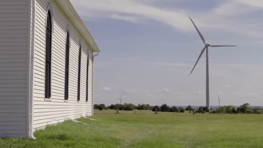 A windmill spins in the field