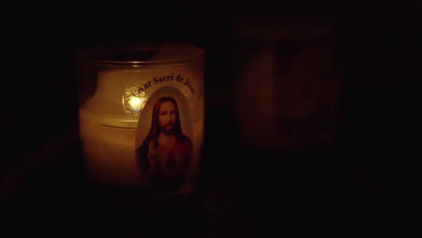 A religious candle burns dimly
