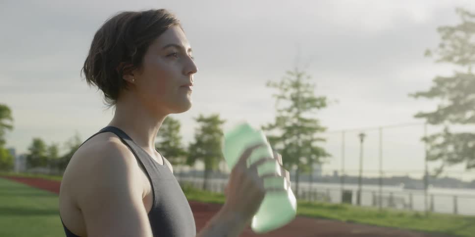 A woman drinks from a water bottle