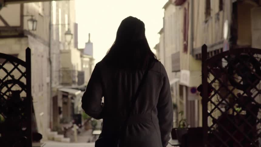 Woman walking through a city street in the afternoon