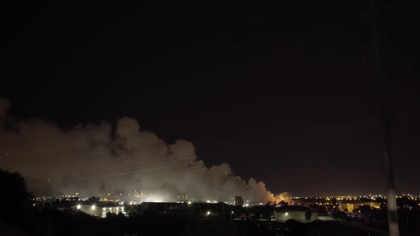 Smoke floats over a city at night