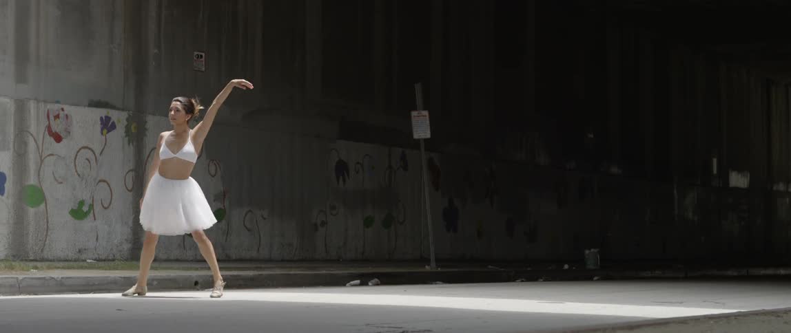 A ballet dancer dances under the bridge