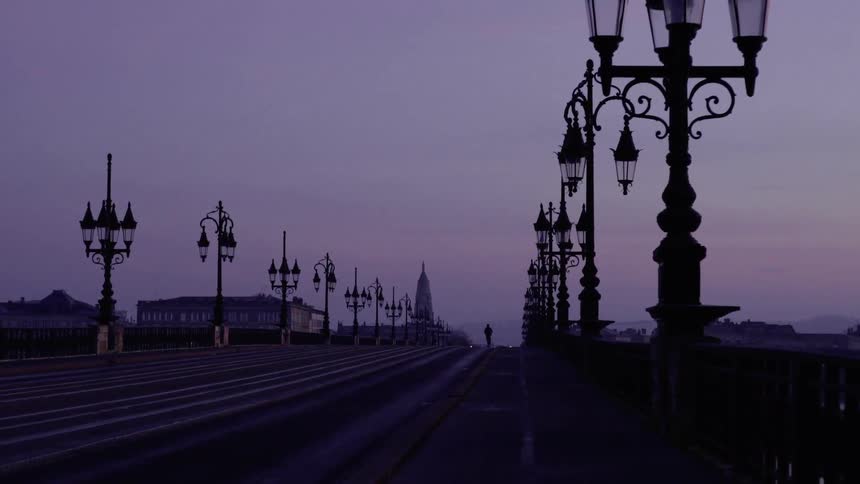 Silhouette of Man on Bridge at Dawn