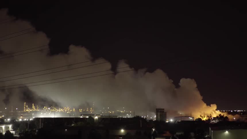 Smoke floats over a city at night
