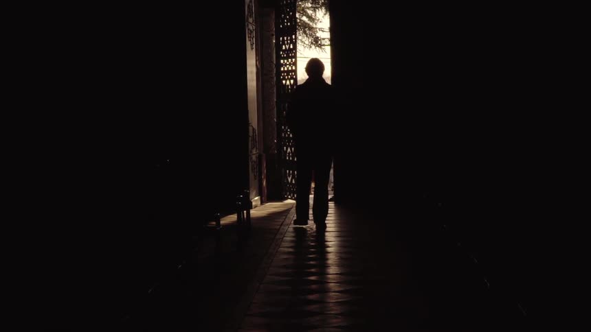 Man walks in the dark between the buildings