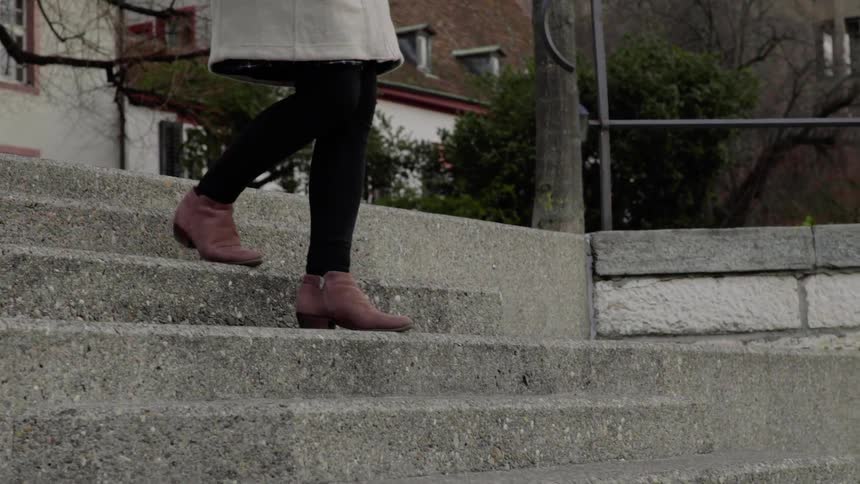 Woman going down steps in the city in the afternoon