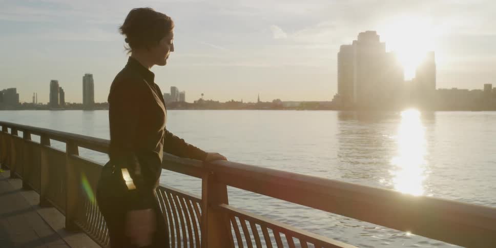A woman stretches by the water