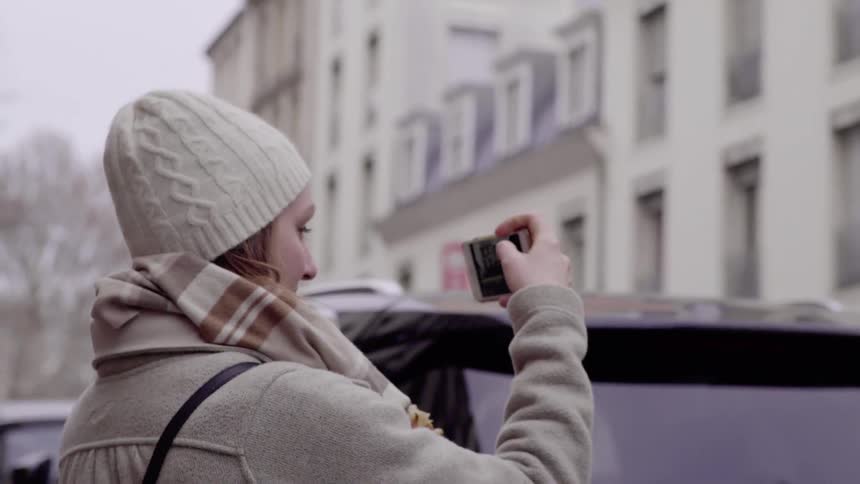 A woman is taking photographs in the city
