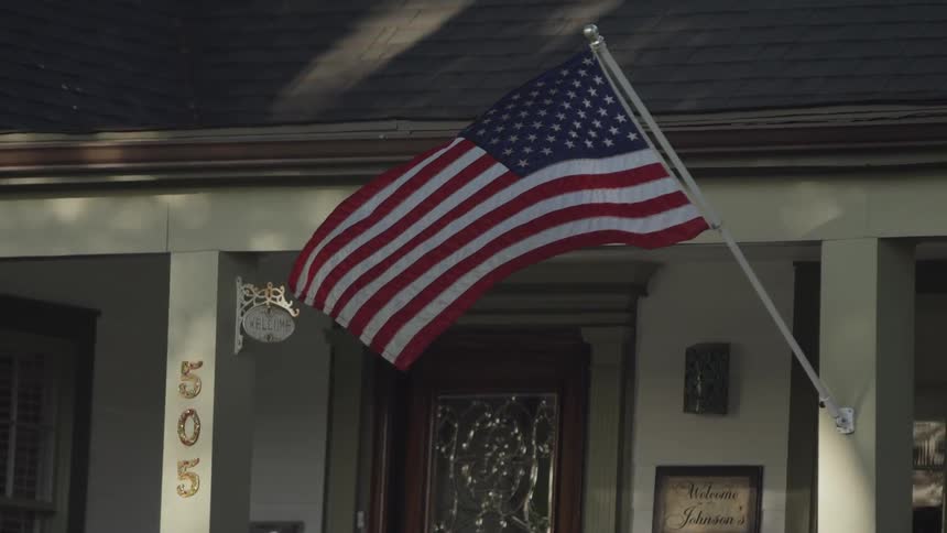 An american flag hangs from a house