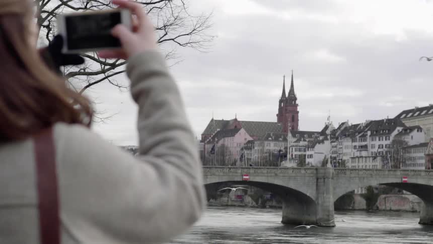 A woman takes a photograph with her phone