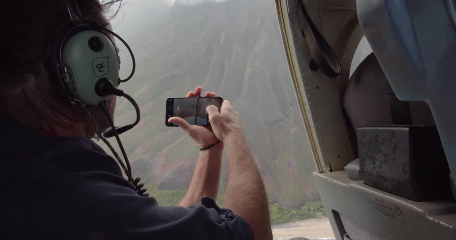 Man in helicopter takes picture with smartphone