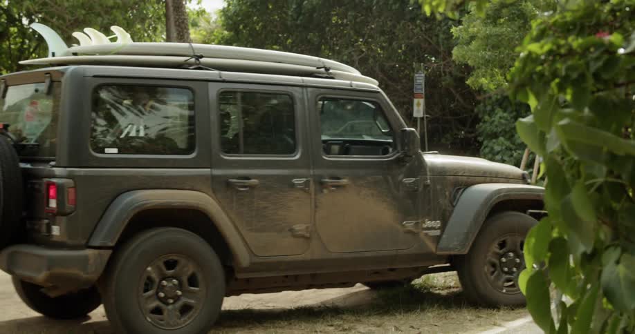 A jeep pulls up to park in the dirt