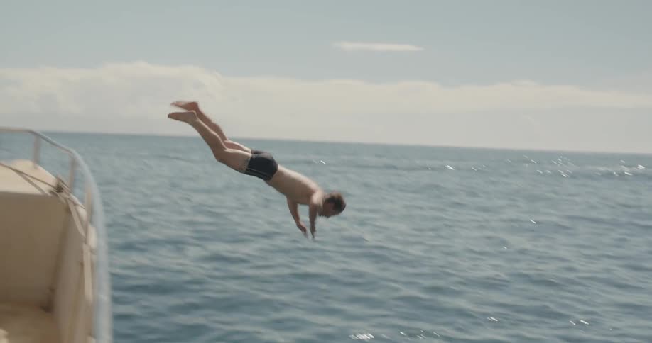 A man dives off the boat into the water