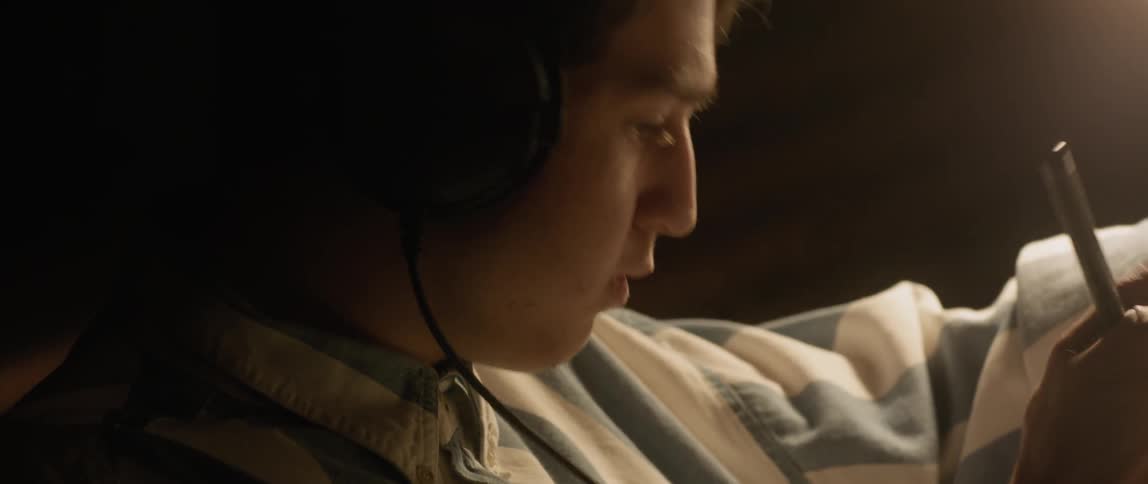 A young man nods his head while he writes