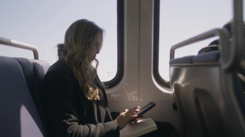 A woman uses her phone on public transportation
