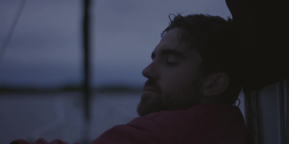 A man sits at dusk