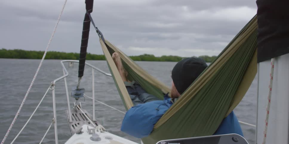 Man swings in hammock on a boat