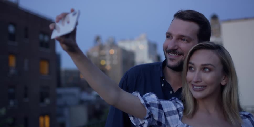 A woman takes a selfie of herself and a man