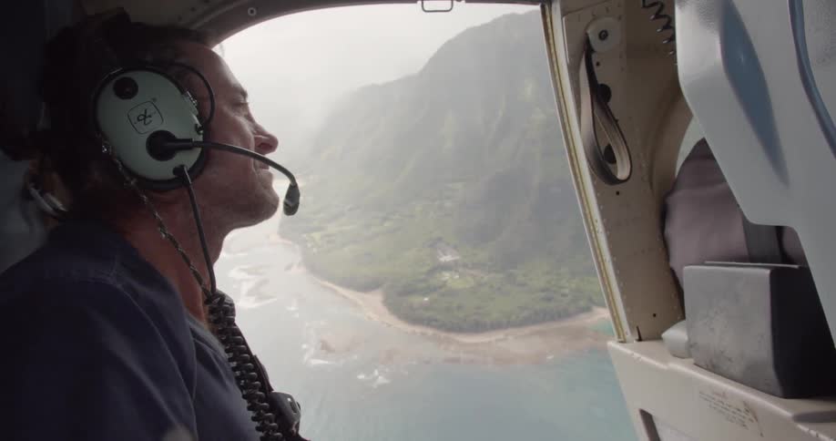 A man looks out of a flying helicopter