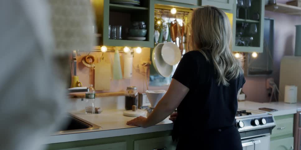 Woman is standing still at kitchen counter