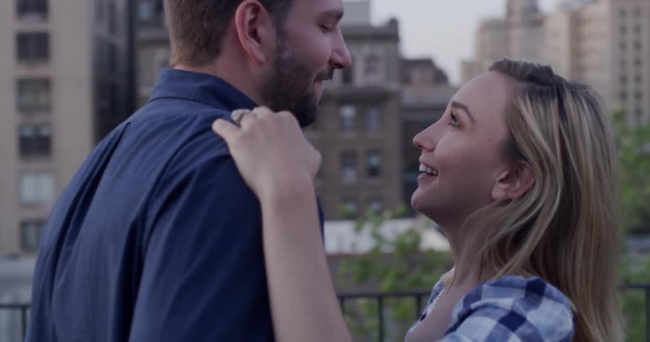 Man and woman dance outside on a balcony