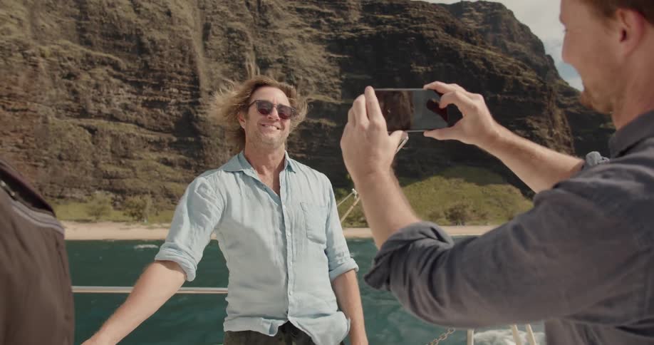 A man takes a photo of another man on the boat