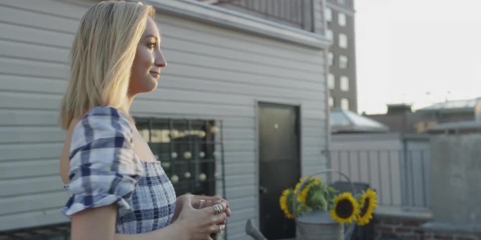 A woman holds a glass of red wine on the balcony