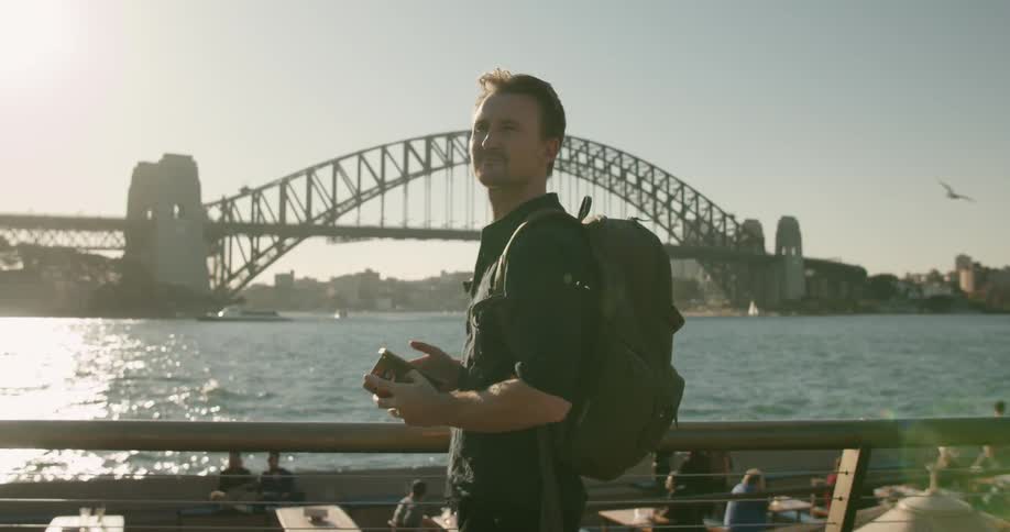 A man takes a photograph of the bridge