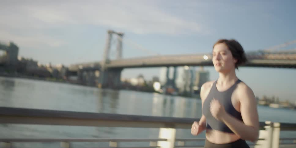A woman jogs next to the water