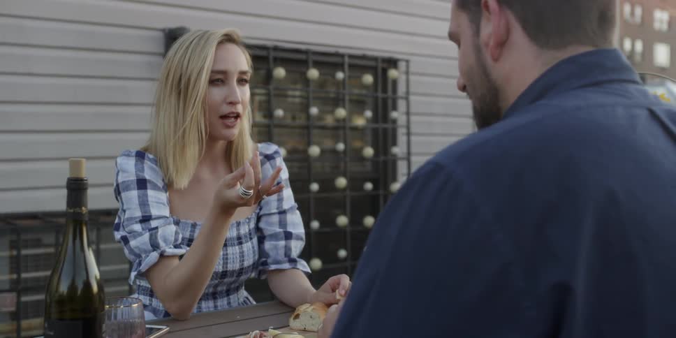Man and woman sitting outside eating at a table