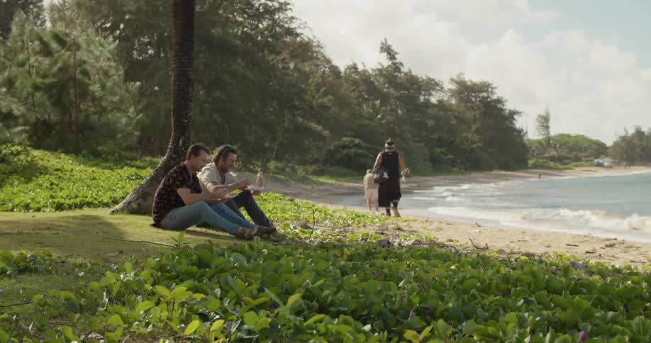 People sit and walk past the shore on a windy day