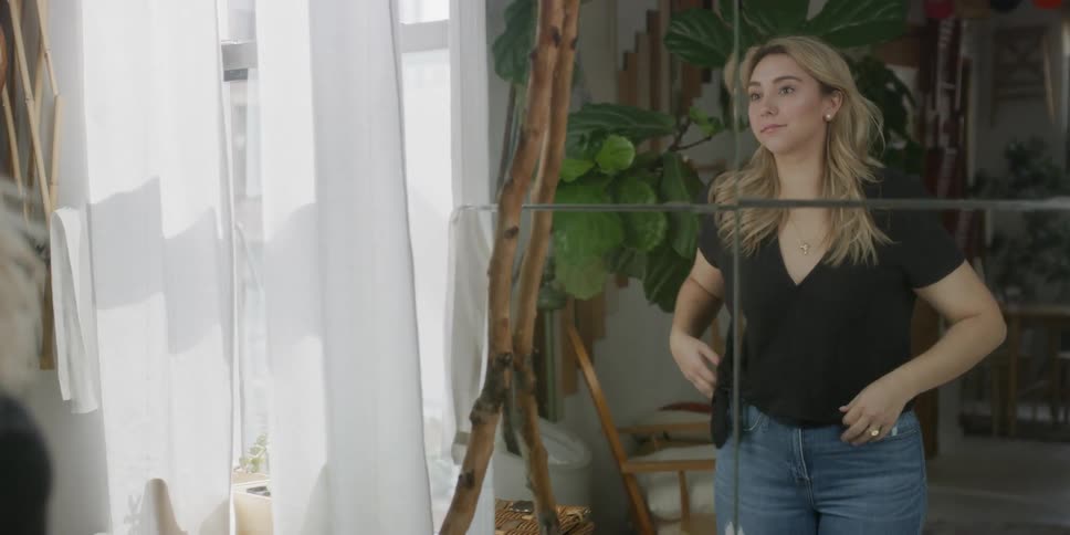 A woman walks up to a mirror