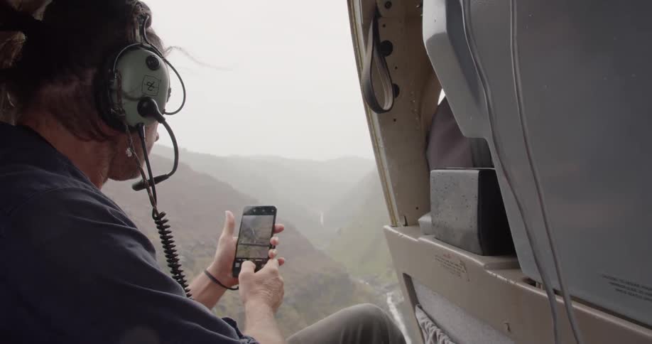 A man riding in a pilot uses his cell phone
