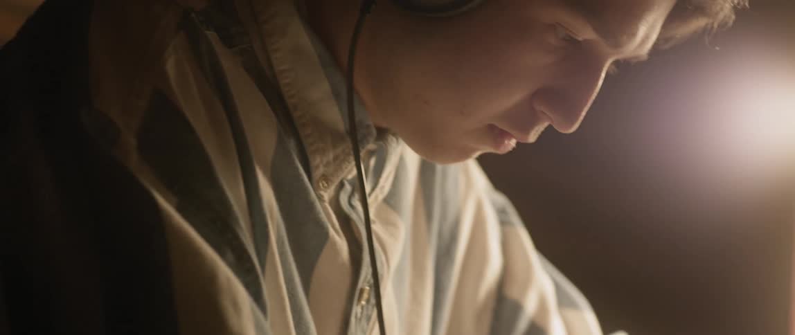 A young man studies while wearing headphones
