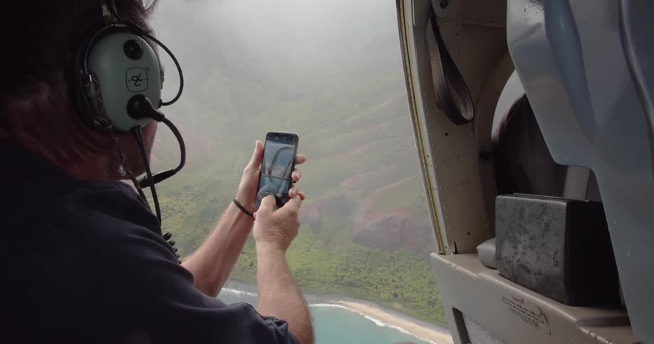 A man checks his phone on the helicopter
