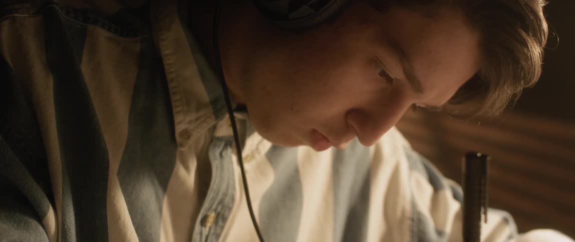 A young man studies while wearing headphones
