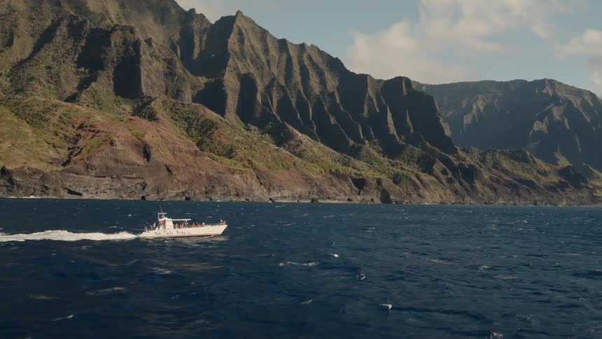 White boat travels down a river near the mountains