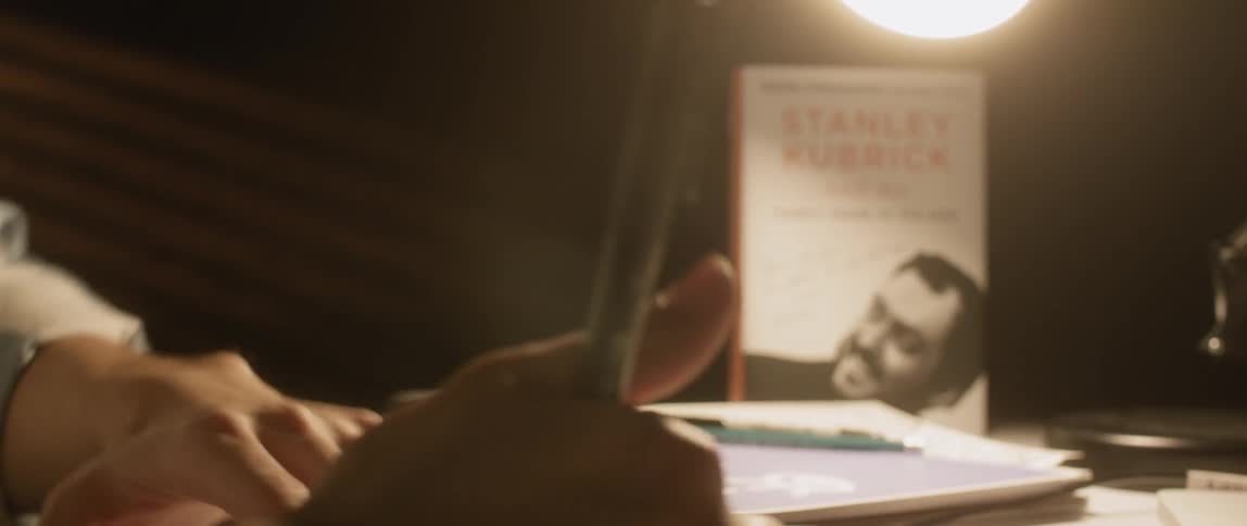A young man writes on a desk