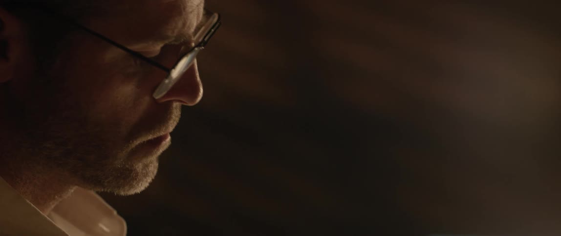Man wearing glasses tilts his head and blinks