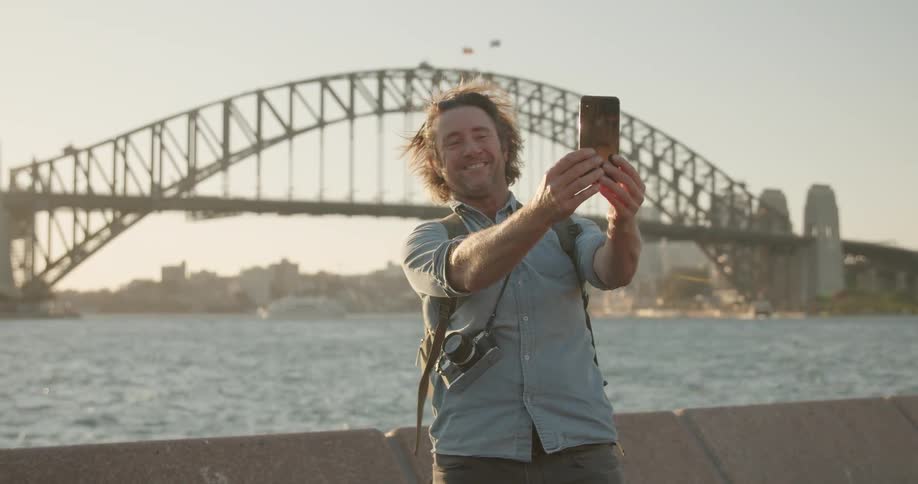 A man takes a selfie near the water