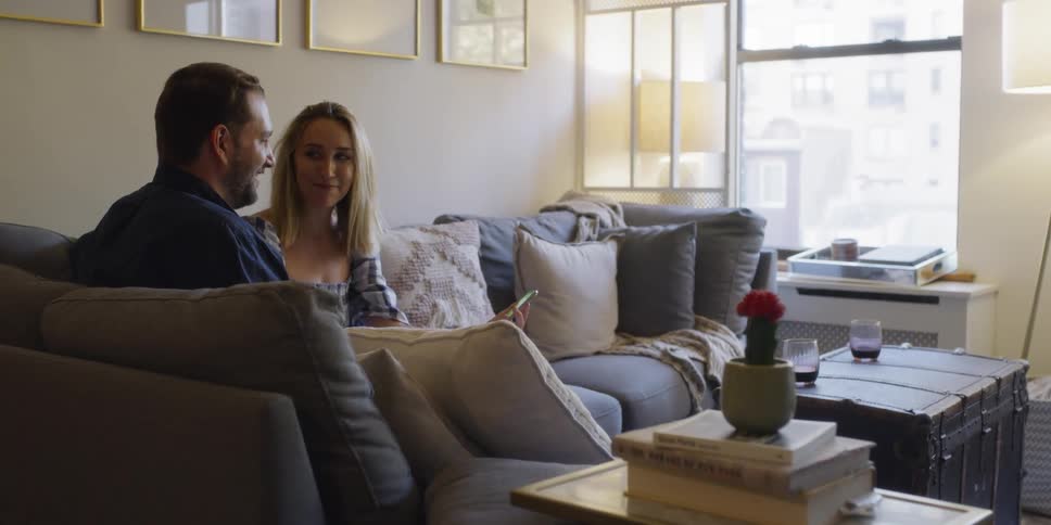 A man and woman sit on the couch